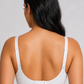 A woman shown from the back wearing a white sports bra and black athletic shorts against a light gray studio background.