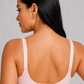 A woman shown from the back wearing a light pink two-piece lingerie set consisting of a bralette and high-waisted briefs, against a neutral gray studio background.