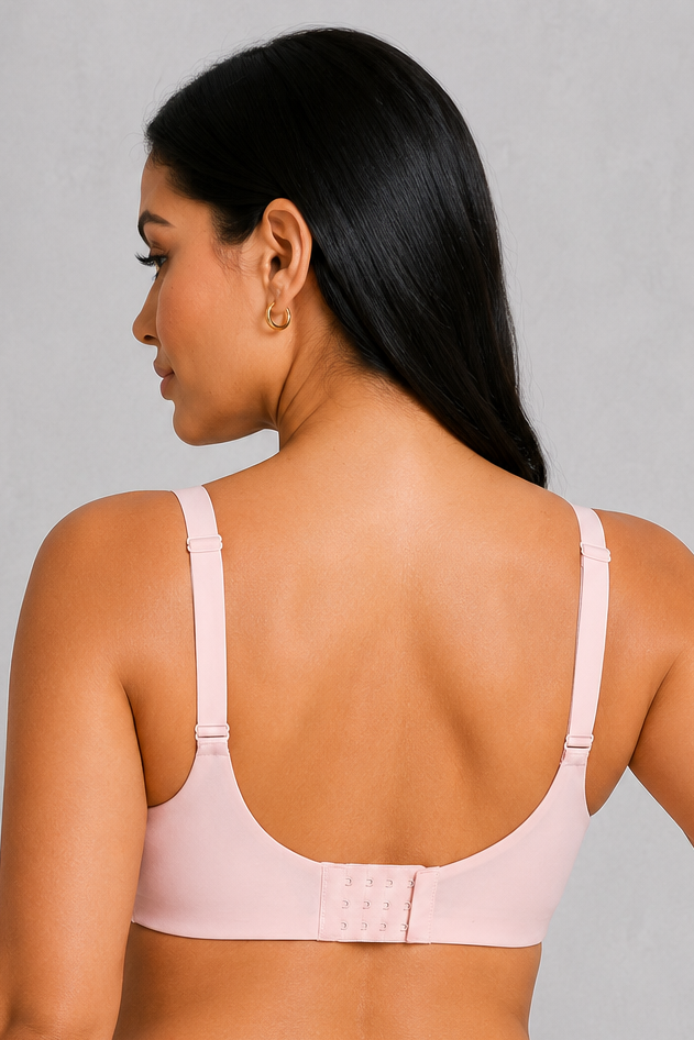 A woman shown from the back wearing a light pink two-piece lingerie set consisting of a bralette and high-waisted briefs, against a neutral gray studio background.