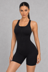 Sculp zip-front racerback gym romper in black, front view
