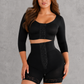 A woman modeling a black two-piece shapewear set consisting of a cropped long-sleeve top and matching high-waisted shorts with lace trim and front lace-up detailing, set against a textured gray studio background.