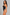 A woman modeling a black one-piece swimsuit with a keyhole cutout at the bust, photographed against a textured light gray studio background.