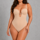 A woman modeling a nude-beige underbust bodysuit with a keyhole cutout at the bust, set against a textured gray studio background.