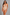 A woman modeling a nude-beige underbust bodysuit with a keyhole cutout at the bust, set against a textured gray studio background.