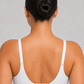 A woman shown from the back wearing a white two-piece swimsuit with a bandeau-style top and high-waisted bottoms against a light gray studio background.
